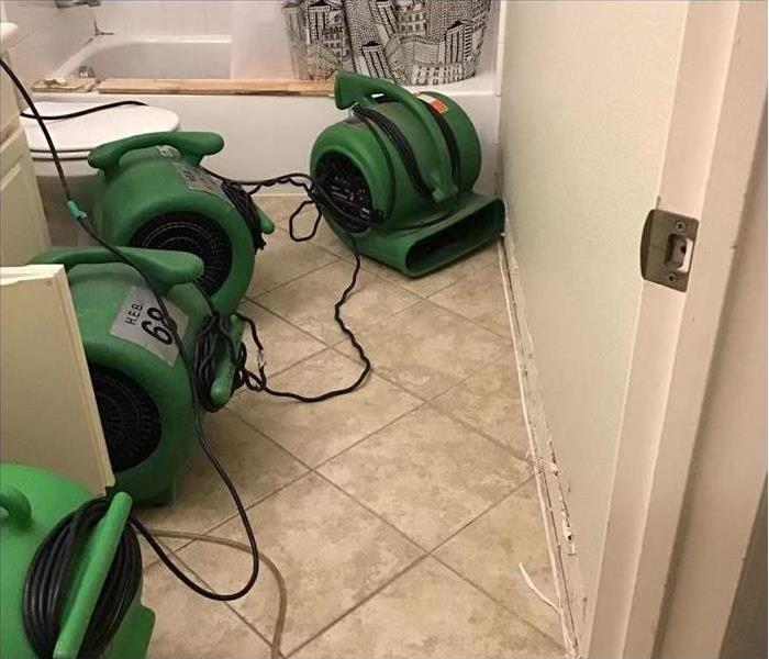 Using equipment to dry water damage in a Fort Worth bathroom.